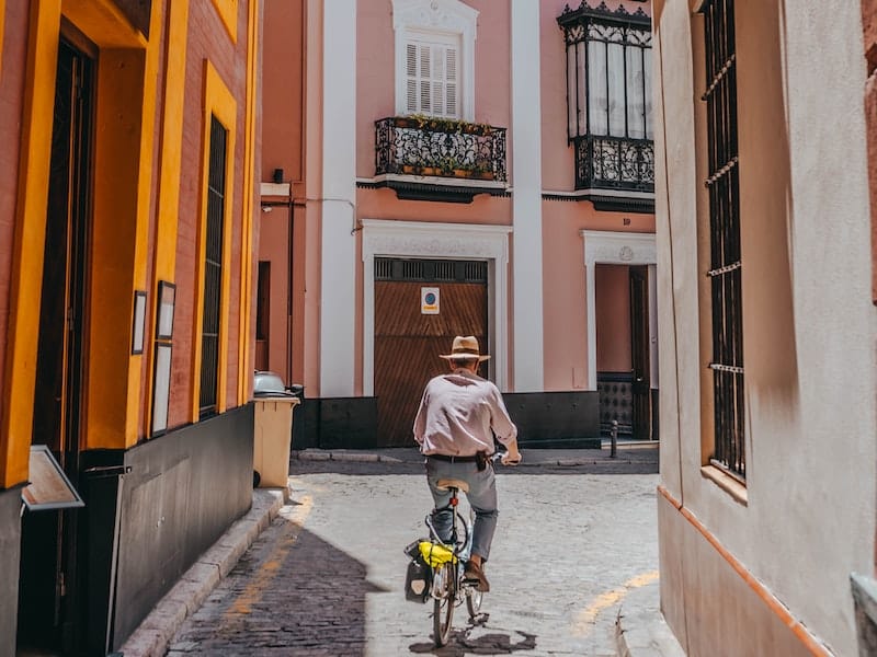 Person riding a bike through the narrow streets of Seville