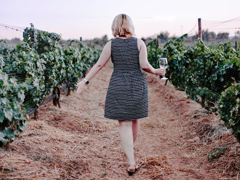 A woman walking through vineyard.